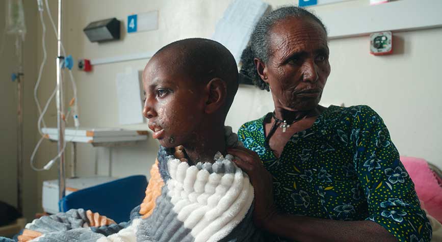 BESELA — child victim in hospital bed with female relative — Photo by Jonny Stern (DP), Amanuel Hailemariam (Cinematographer)