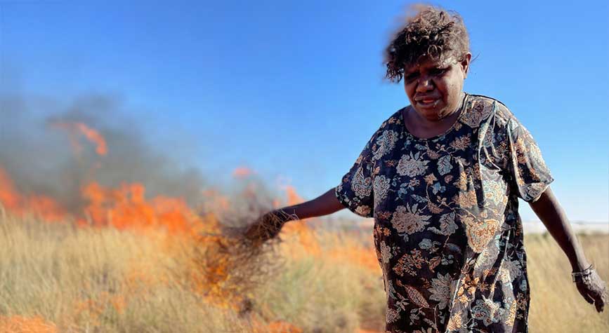 ABOUT Woman performing cultural burning